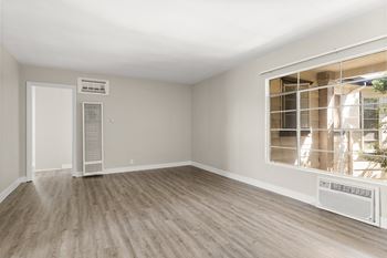 A room with a window and a wall-mounted air conditioner unit.
